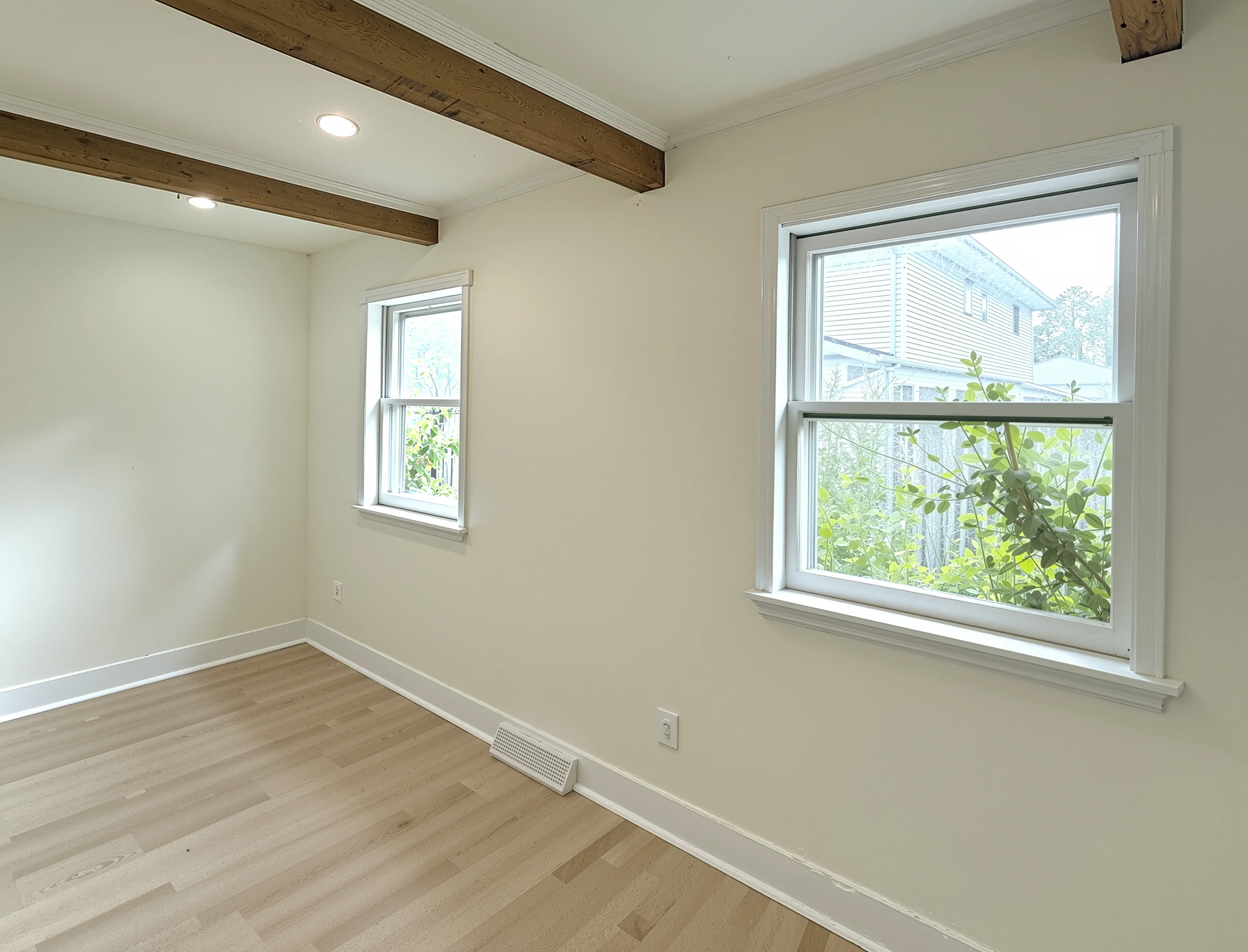 Remodeled room with exposed wood beams and new windows