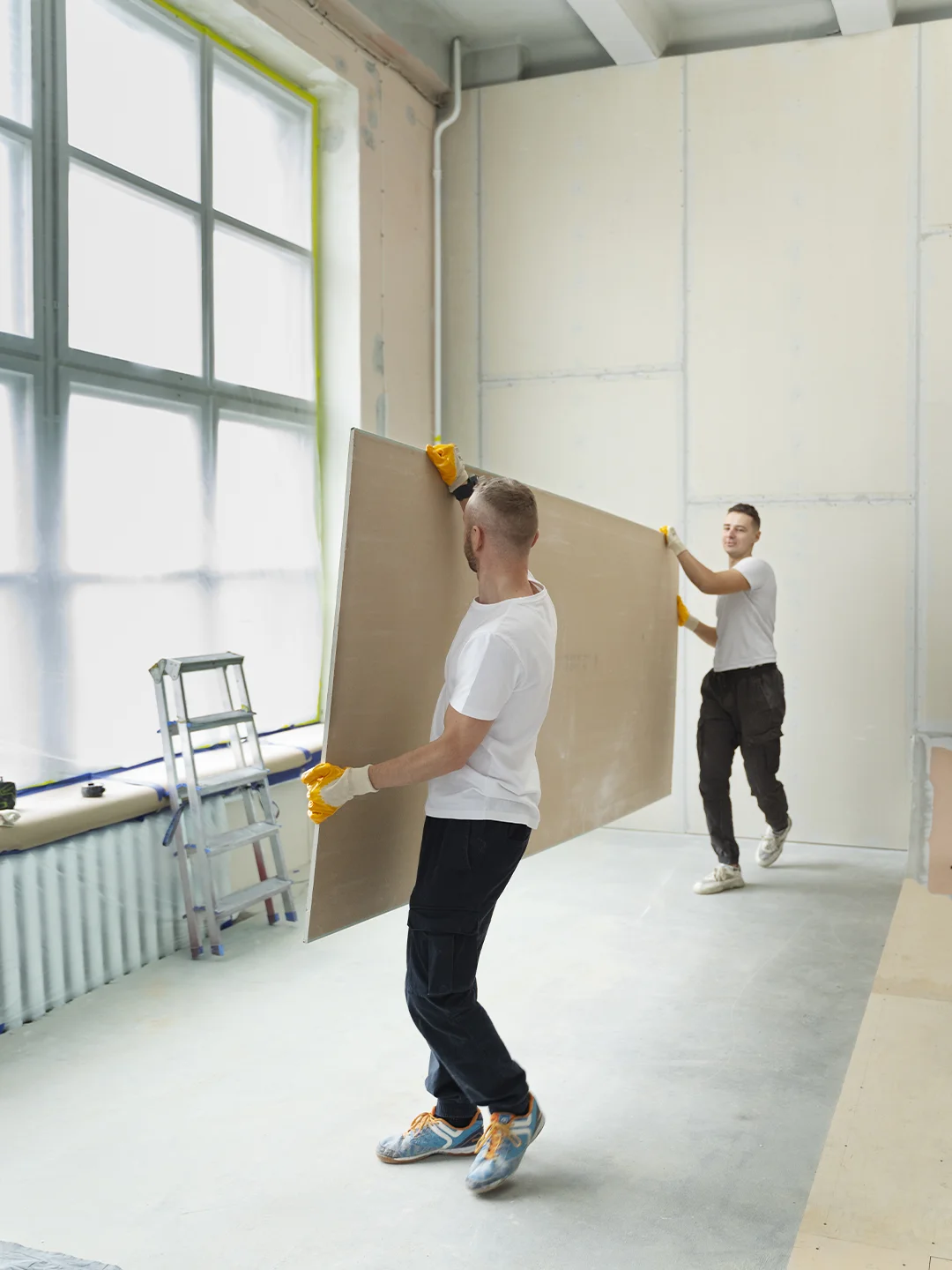 Crew carrying and installing drywall panels